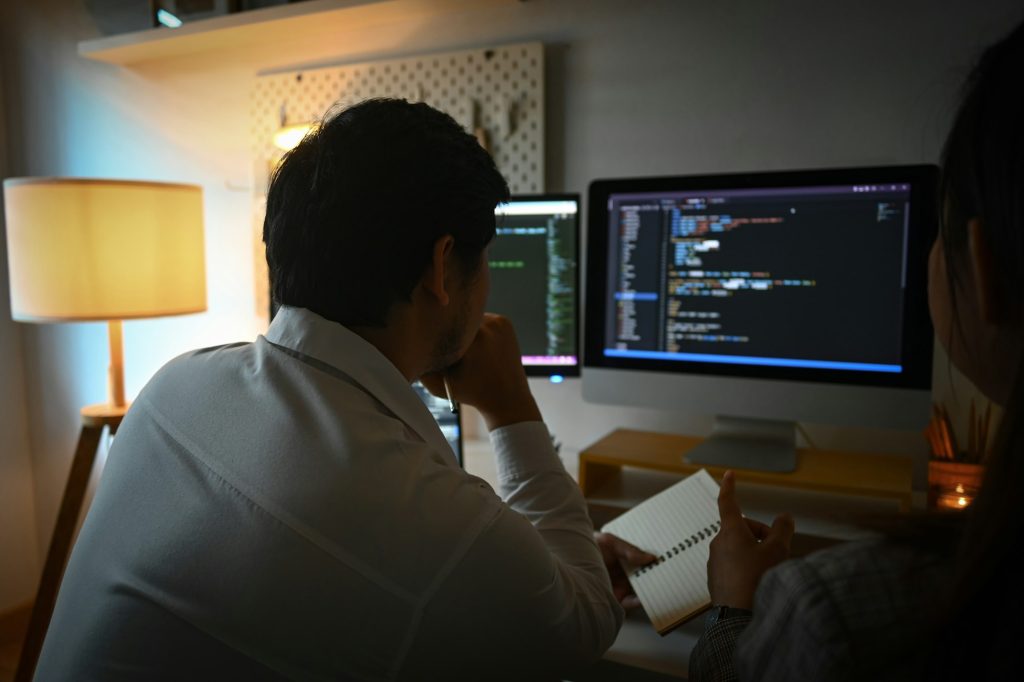 Team of coders brainstorming ideas for developing website design in office at night